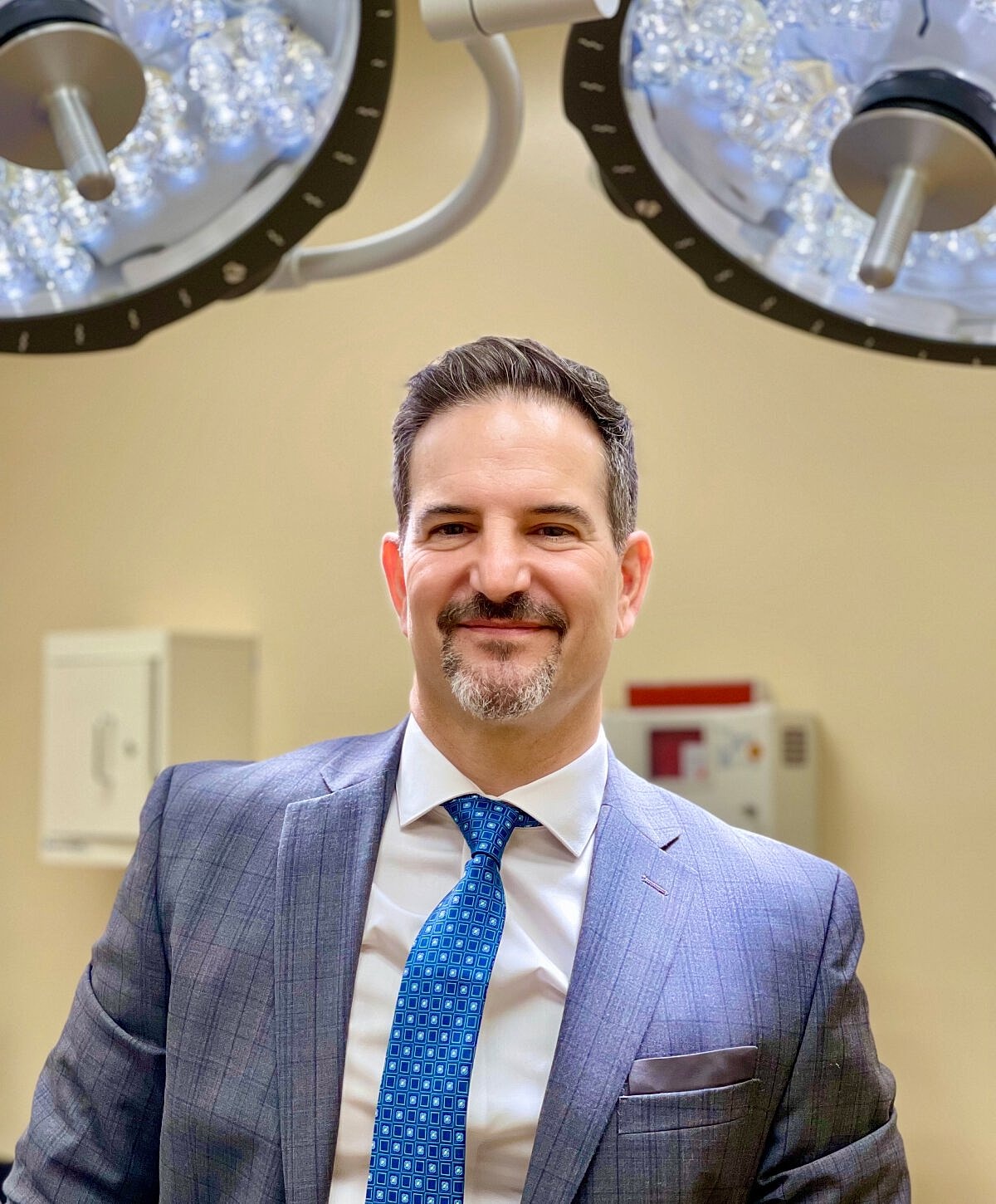Smiling professional in surgical environment.