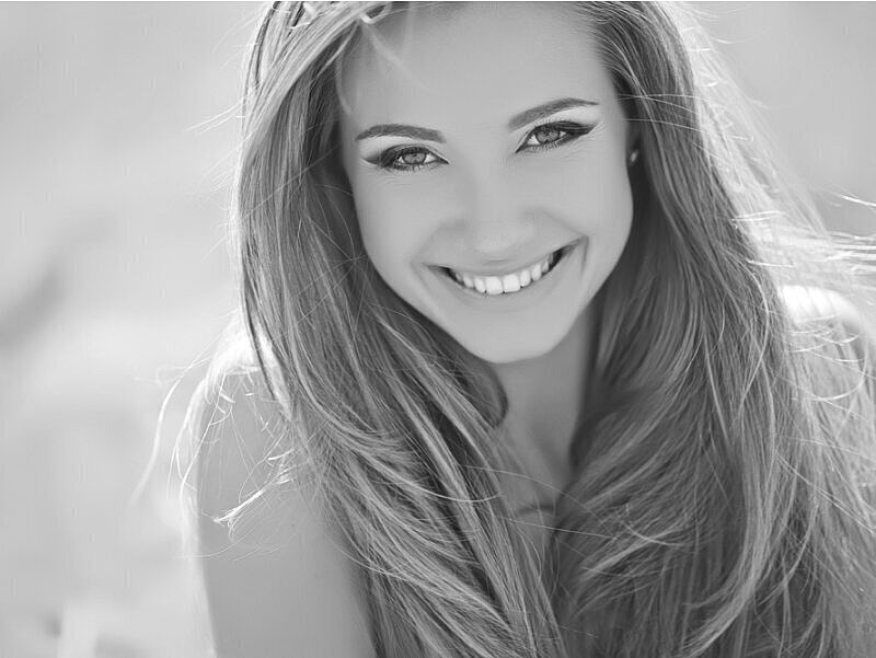 Smiling woman with long hair in black-and-white.