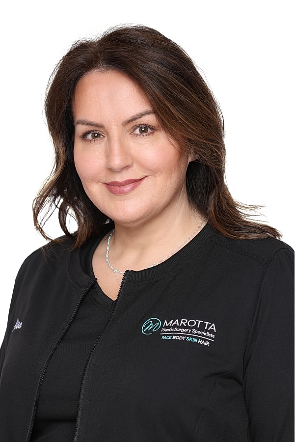 Medical professional in branded attire smiling.