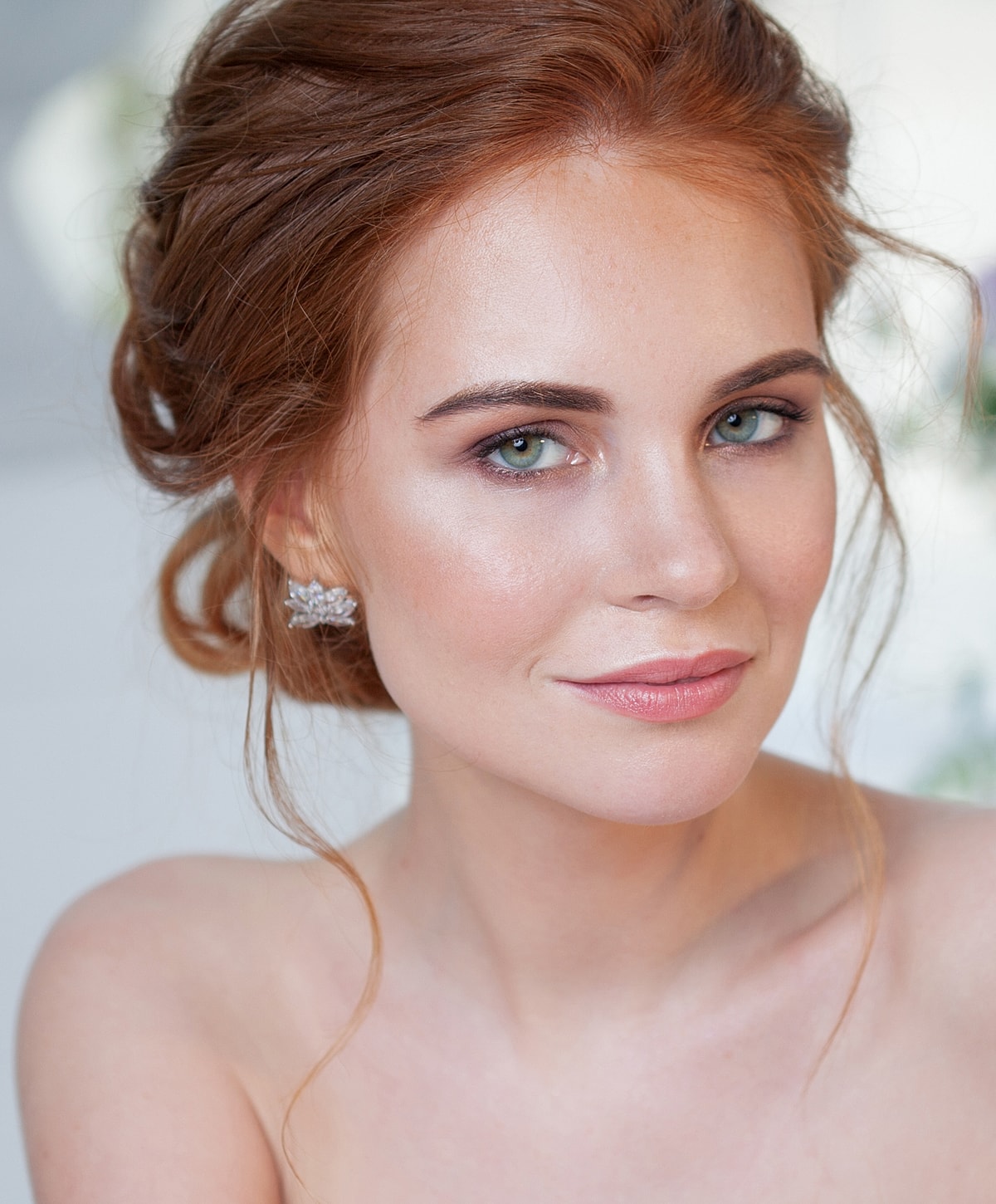 Portrait of woman with red hair and earrings.
