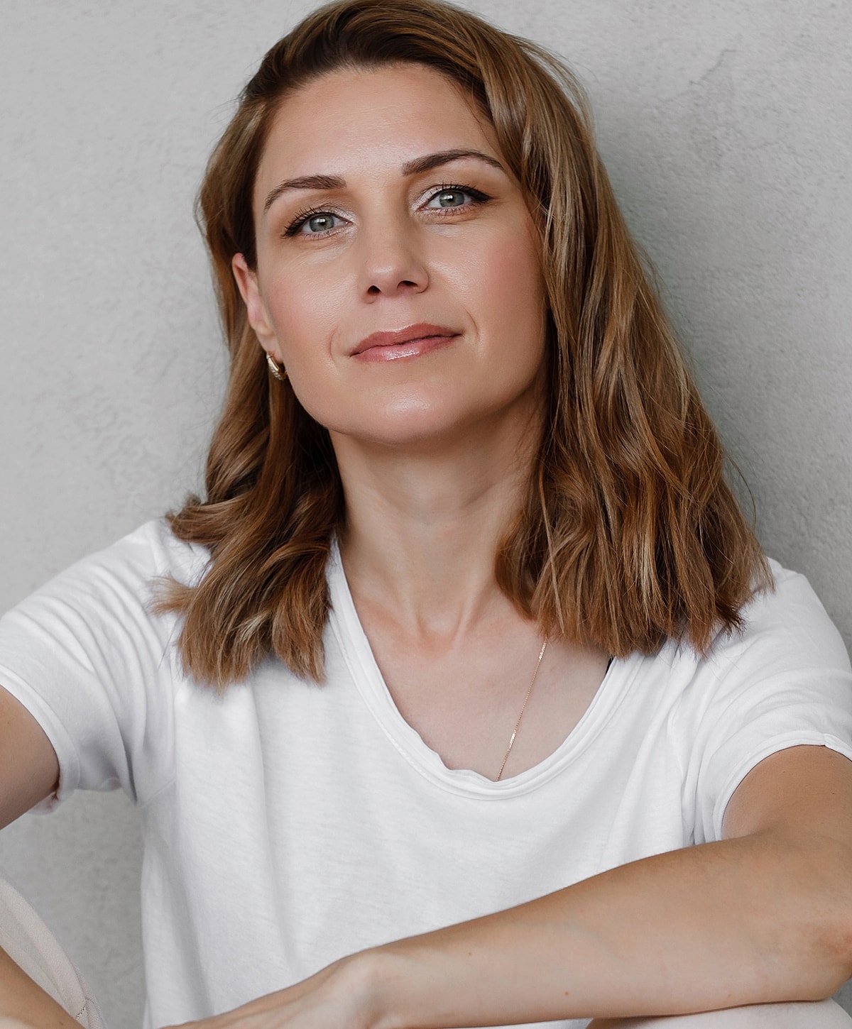 Woman with shoulder-length hair wearing a white shirt.