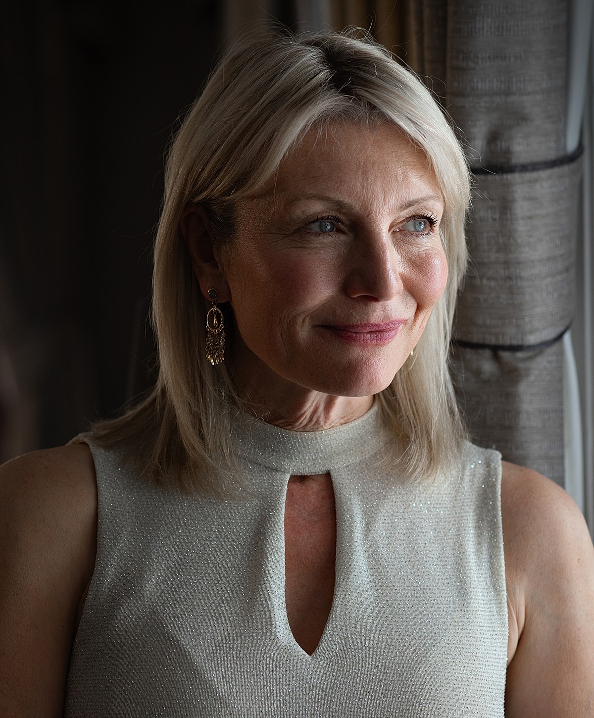 Woman with gray hair and elegant earrings.