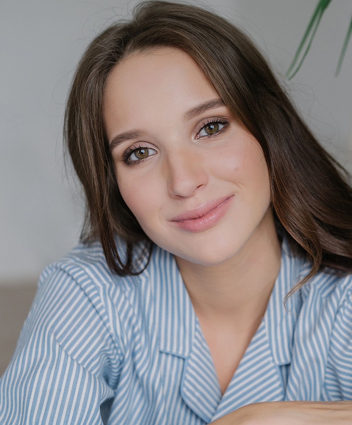 Smiling woman in striped shirt, natural lighting.