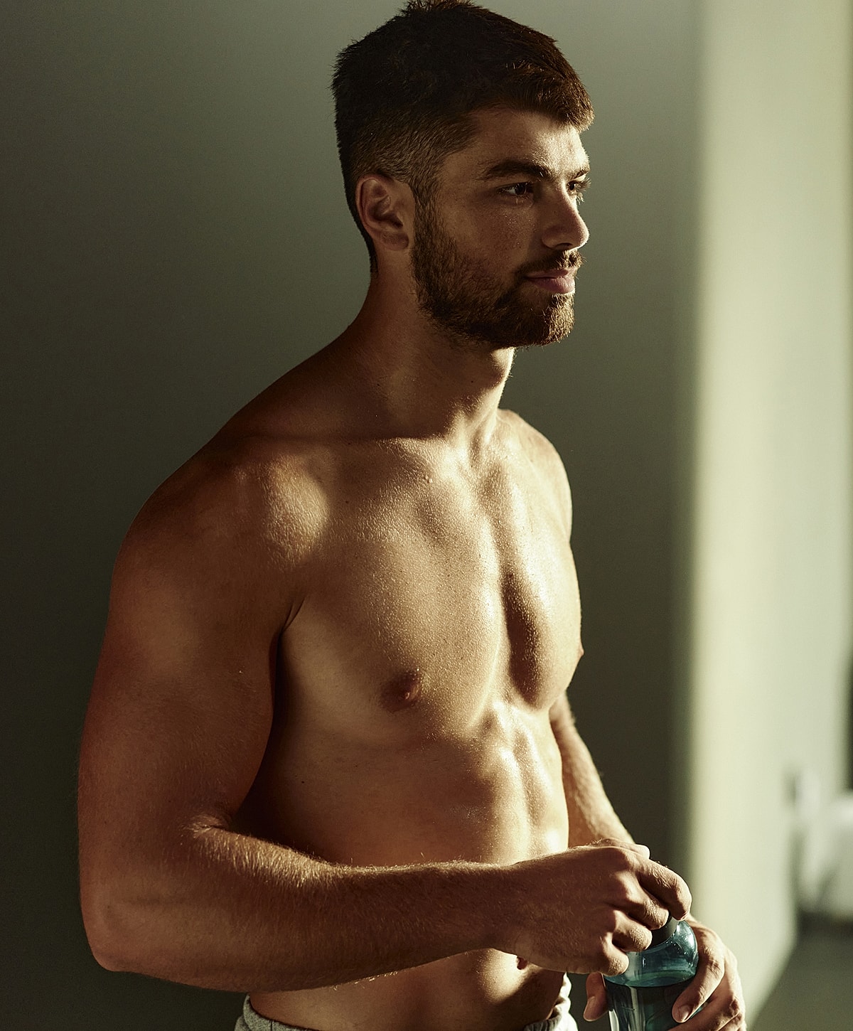 Muscular man holding a water bottle.