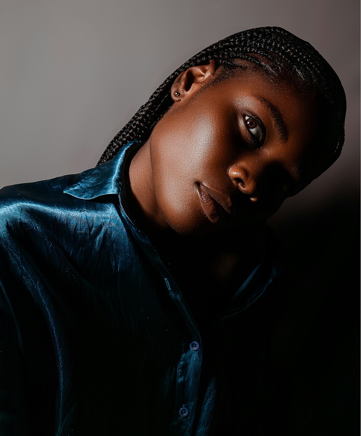 Person with braided hair in blue shirt.