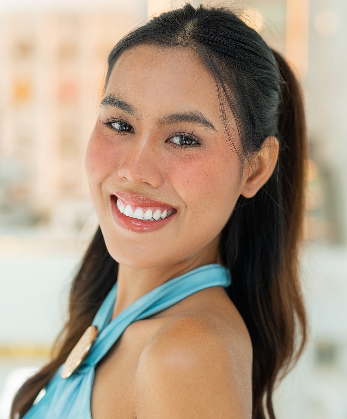Smiling woman with long hair in blue top.