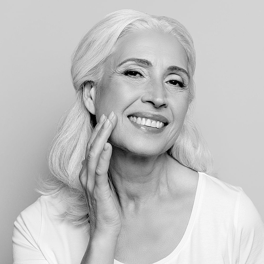 Smiling woman with gray hair in black and white.