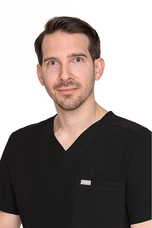 Male in black scrubs, neutral expression.