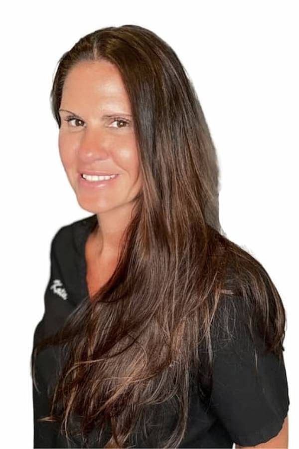 Smiling woman with long hair in black top.