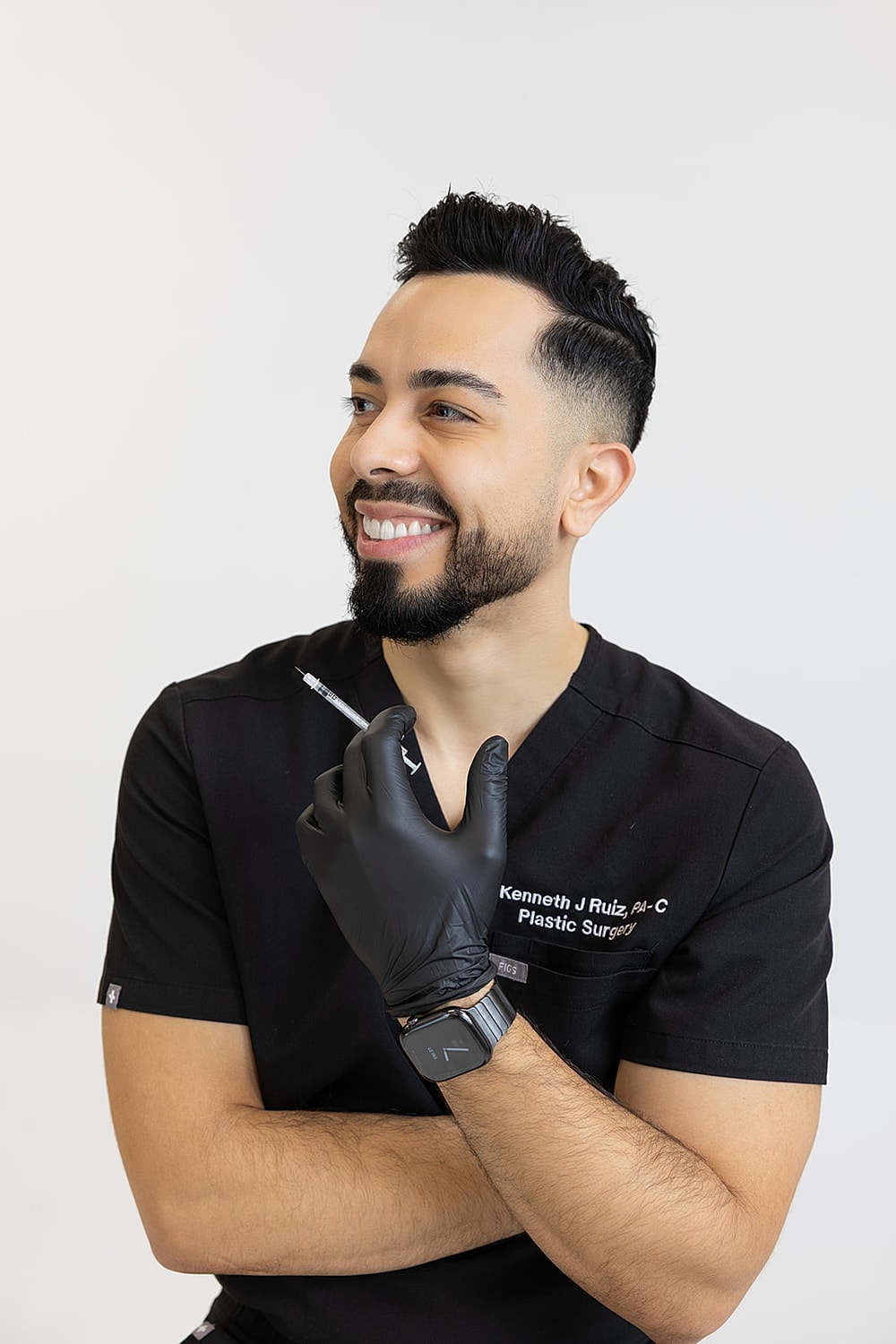 Plastic surgeon smiling with a syringe in hand