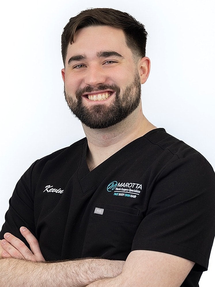 Smiling healthcare professional in black scrubs.