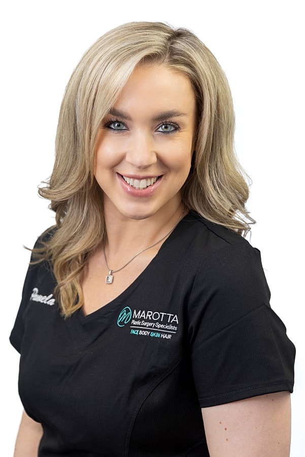 Smiling woman in medical attire with logo.