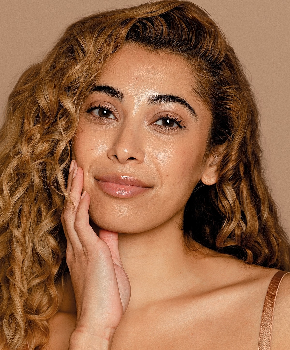 Smiling woman with wavy, textured hair.