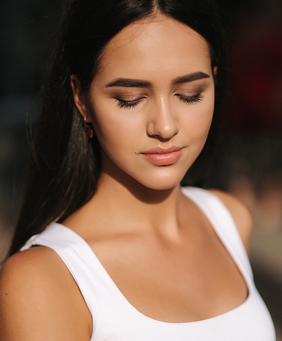 Young woman with closed eyes in sunlight.