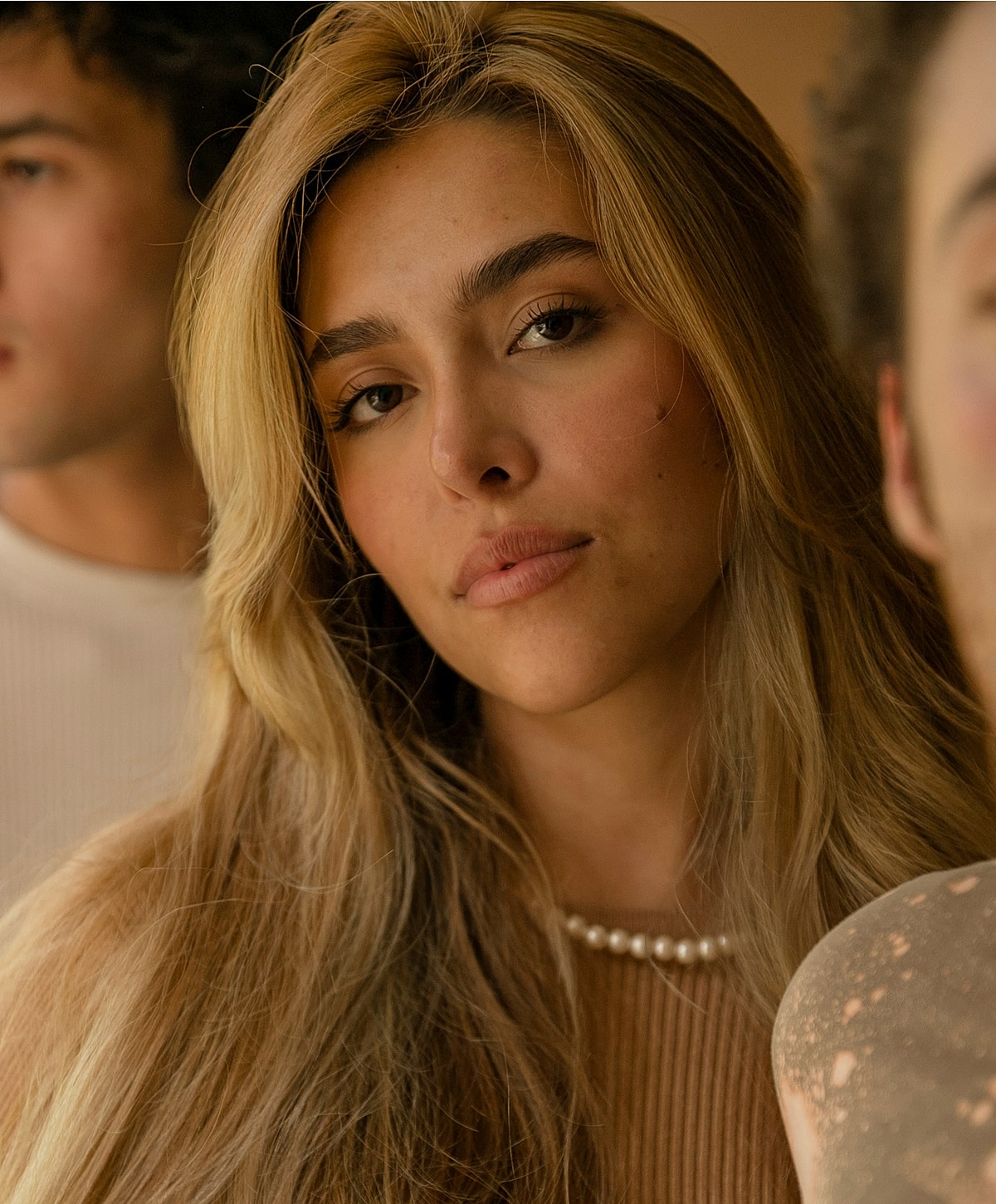 Portrait of a woman with blonde hair and pearls.