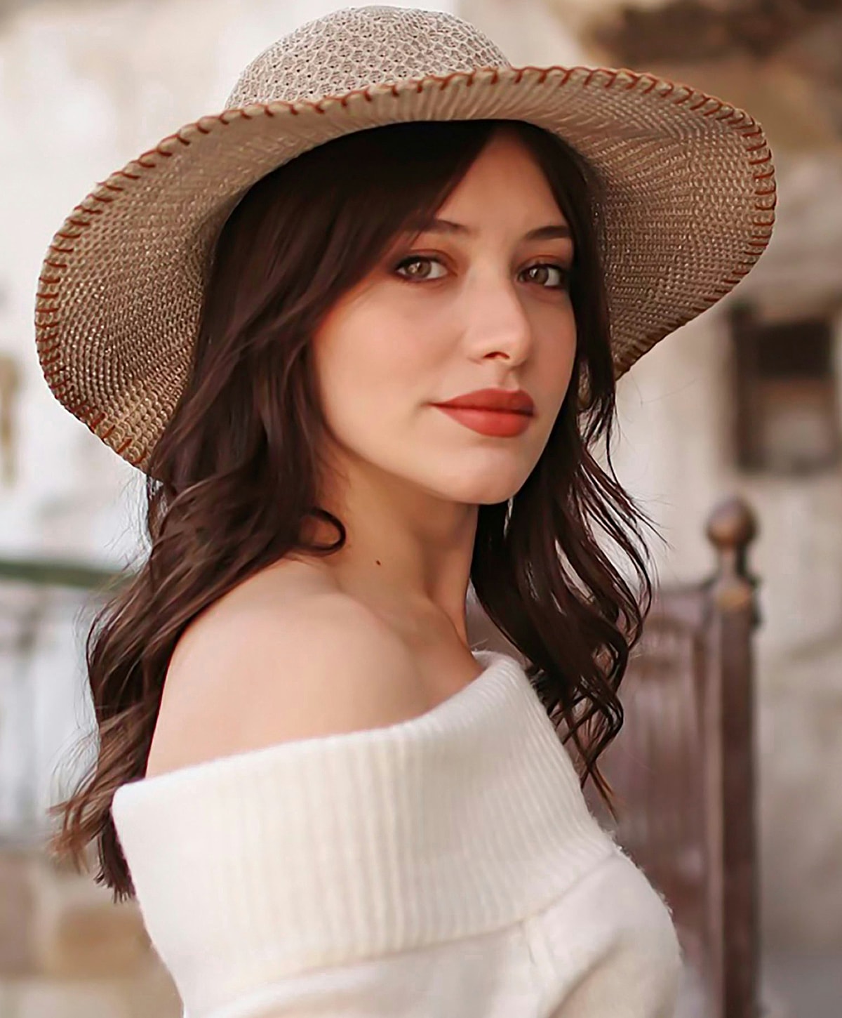 Woman in a straw hat and off-shoulder sweater.