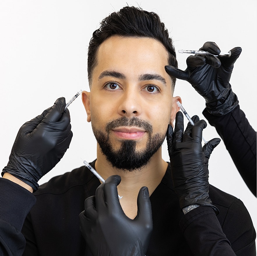 Man receiving cosmetic injections with gloved hands.
