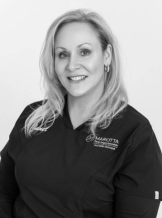 Female medical professional smiling in black scrubs.