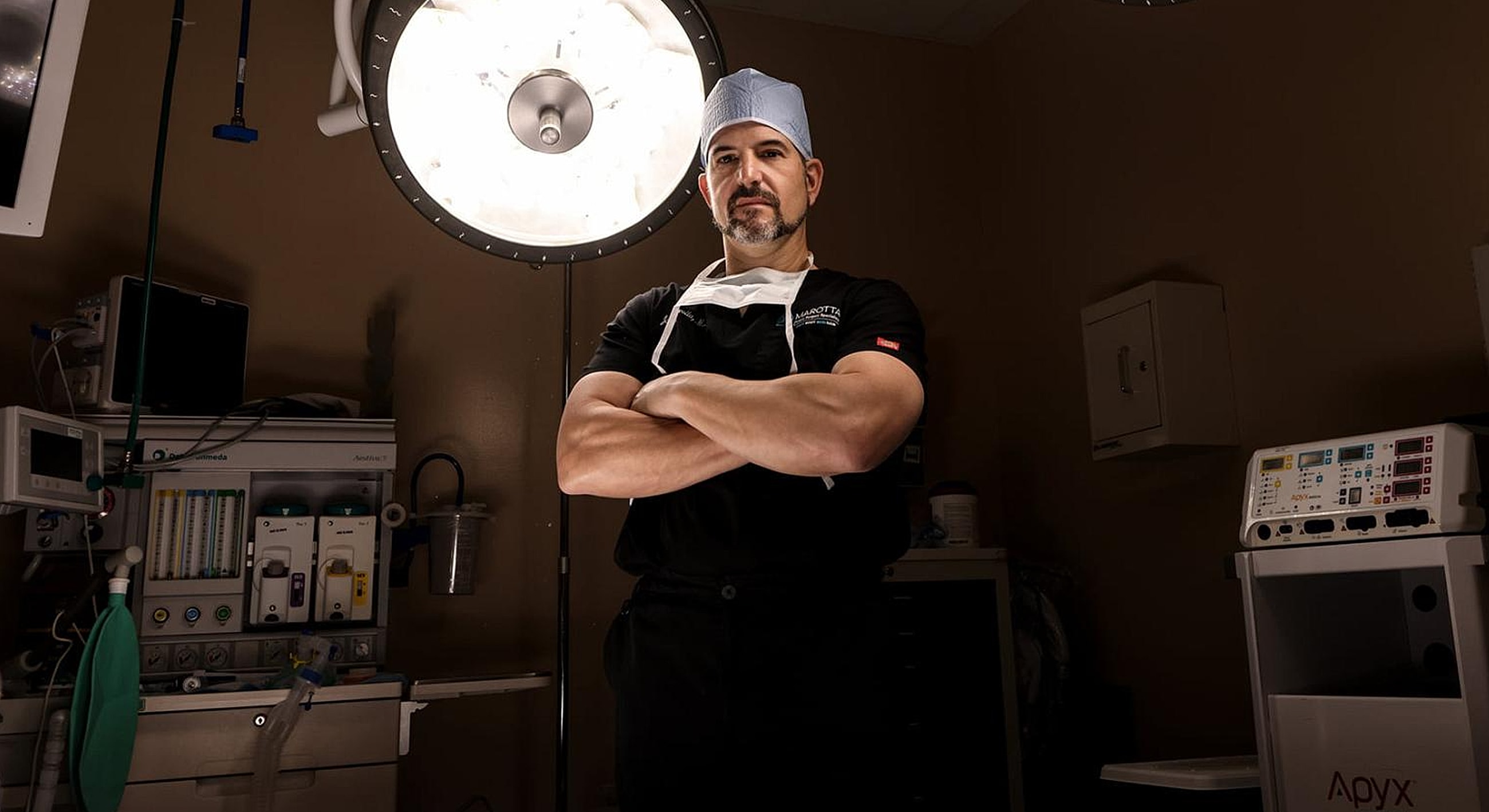 Surgeon posing confidently in operating room.