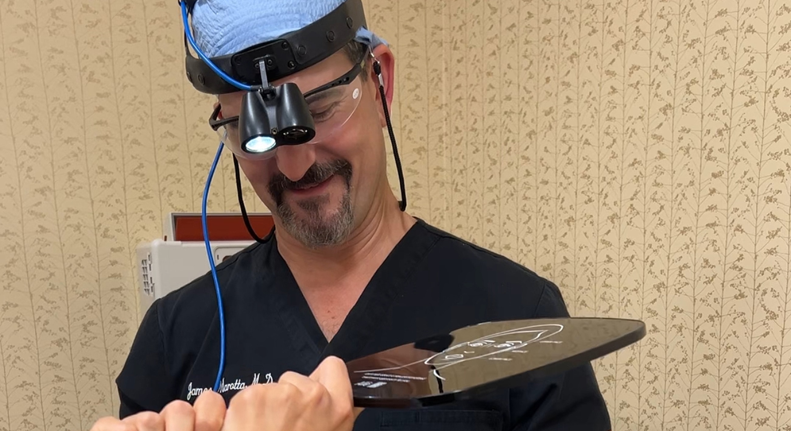 Surgeon examining medical tool with focused expression.