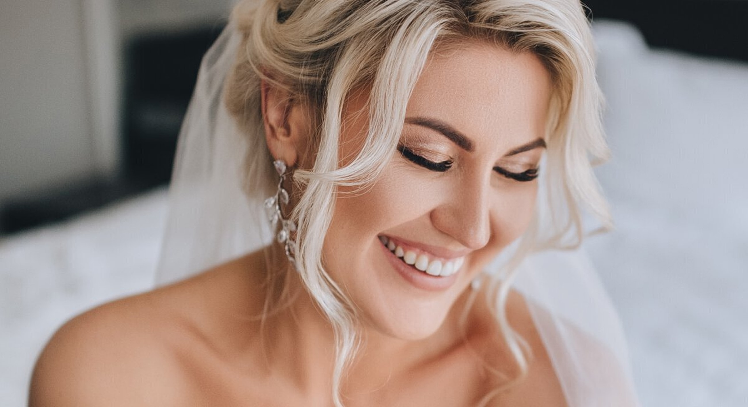 Bride smiling with elegant hairstyle and accessories.