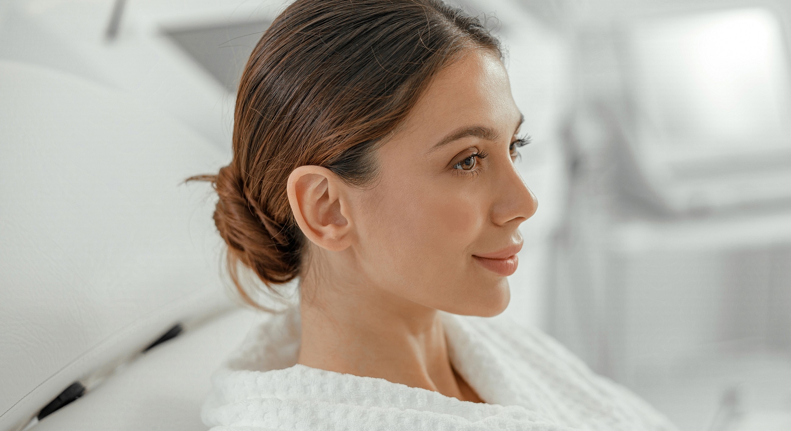 Woman in a spa robe, serene expression.
