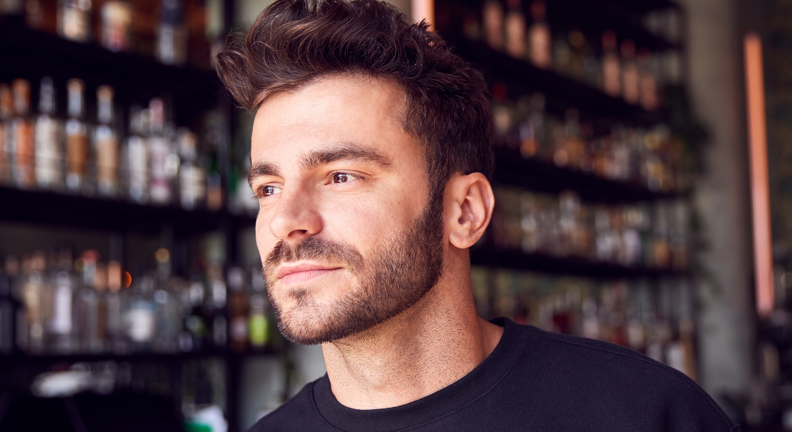 Man smiling in a bar setting.