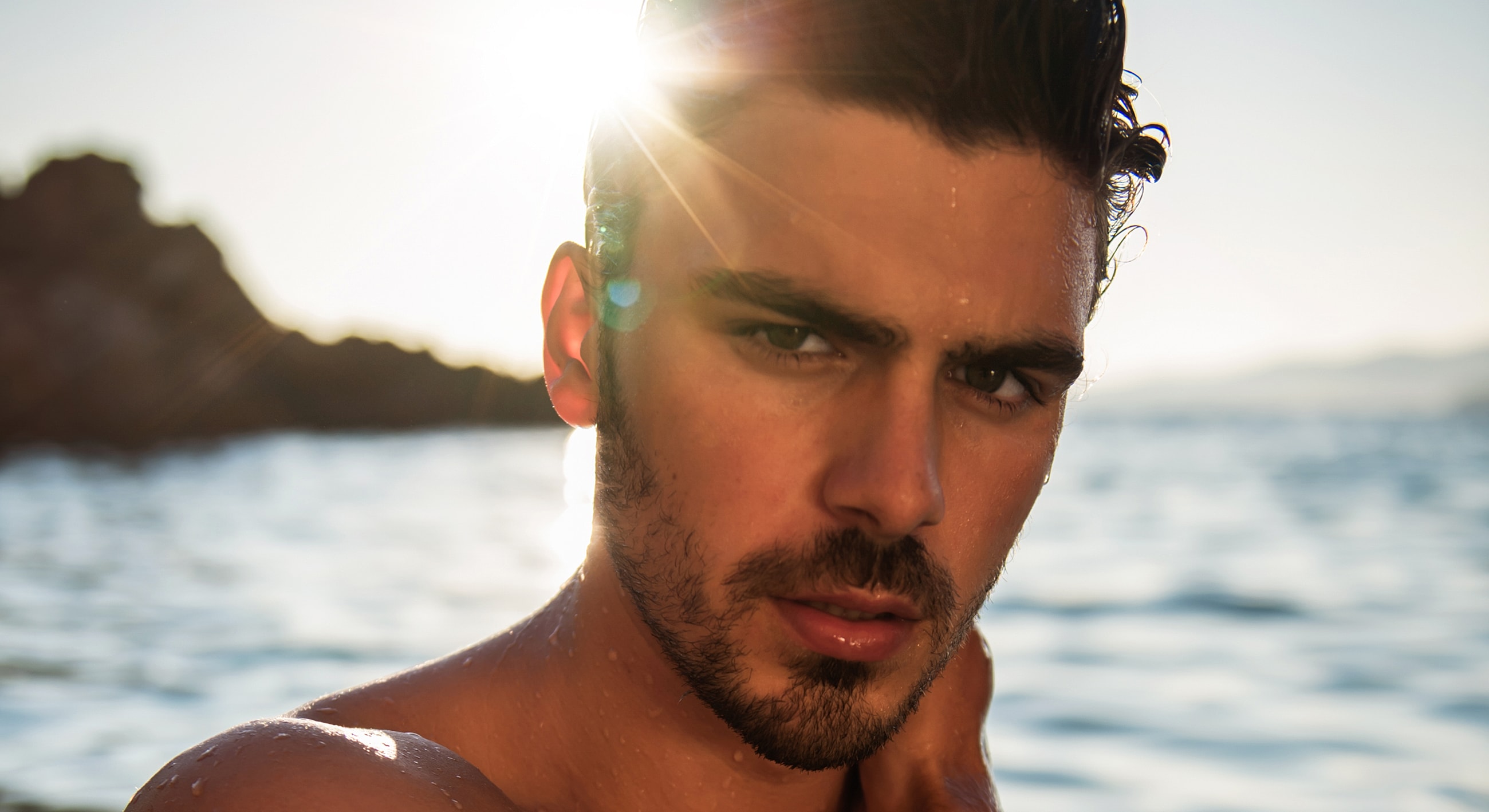 Man with water droplets against a sunlit background.