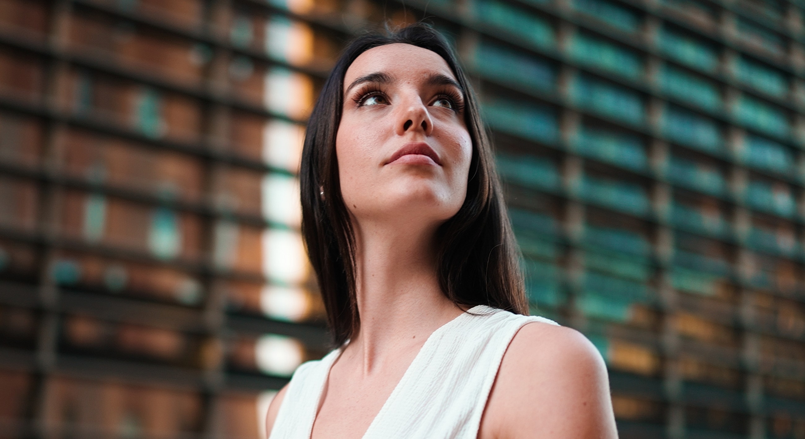 Woman looking up against an urban background.