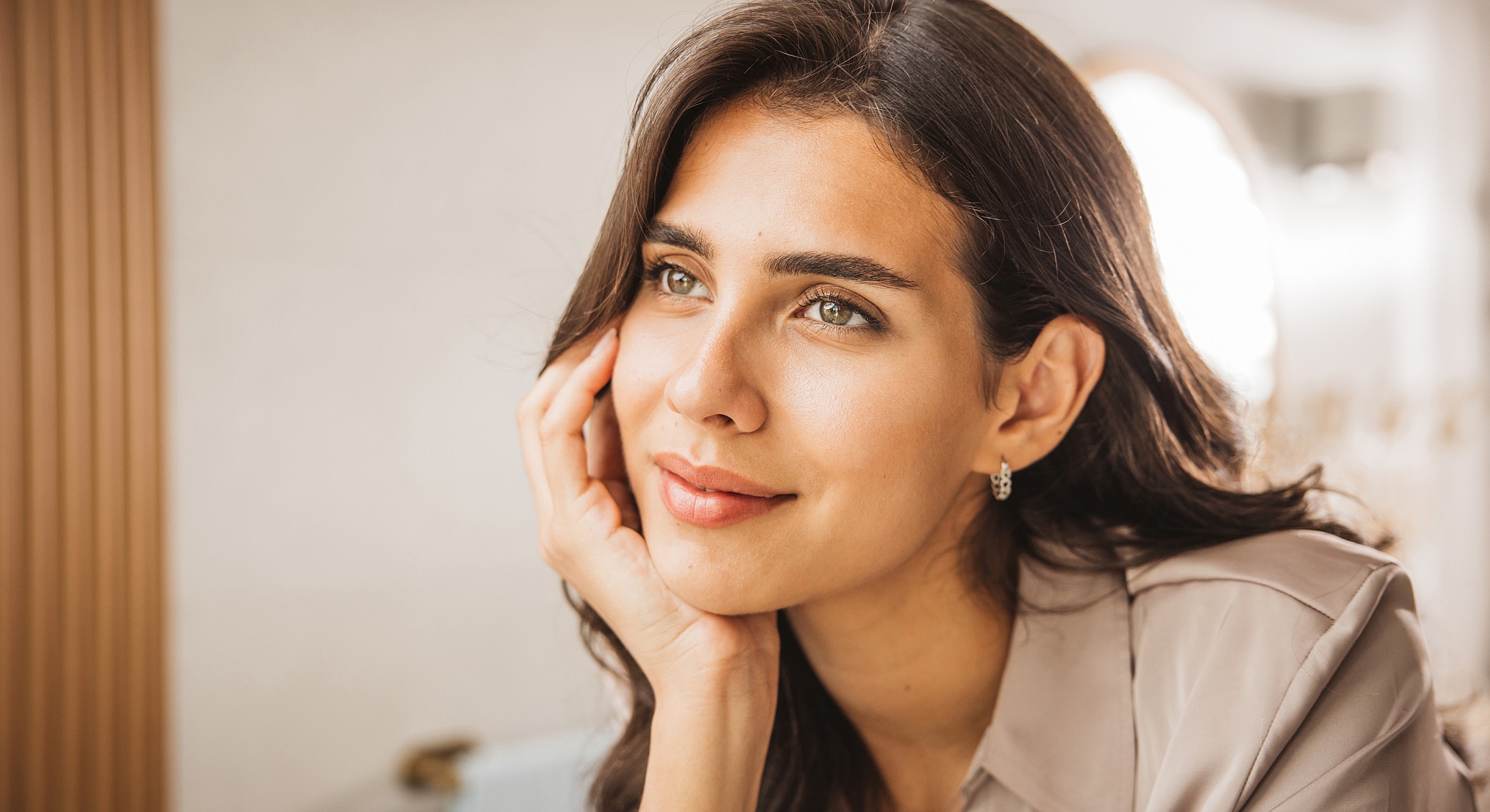 Woman with thoughtful expression and light makeup.