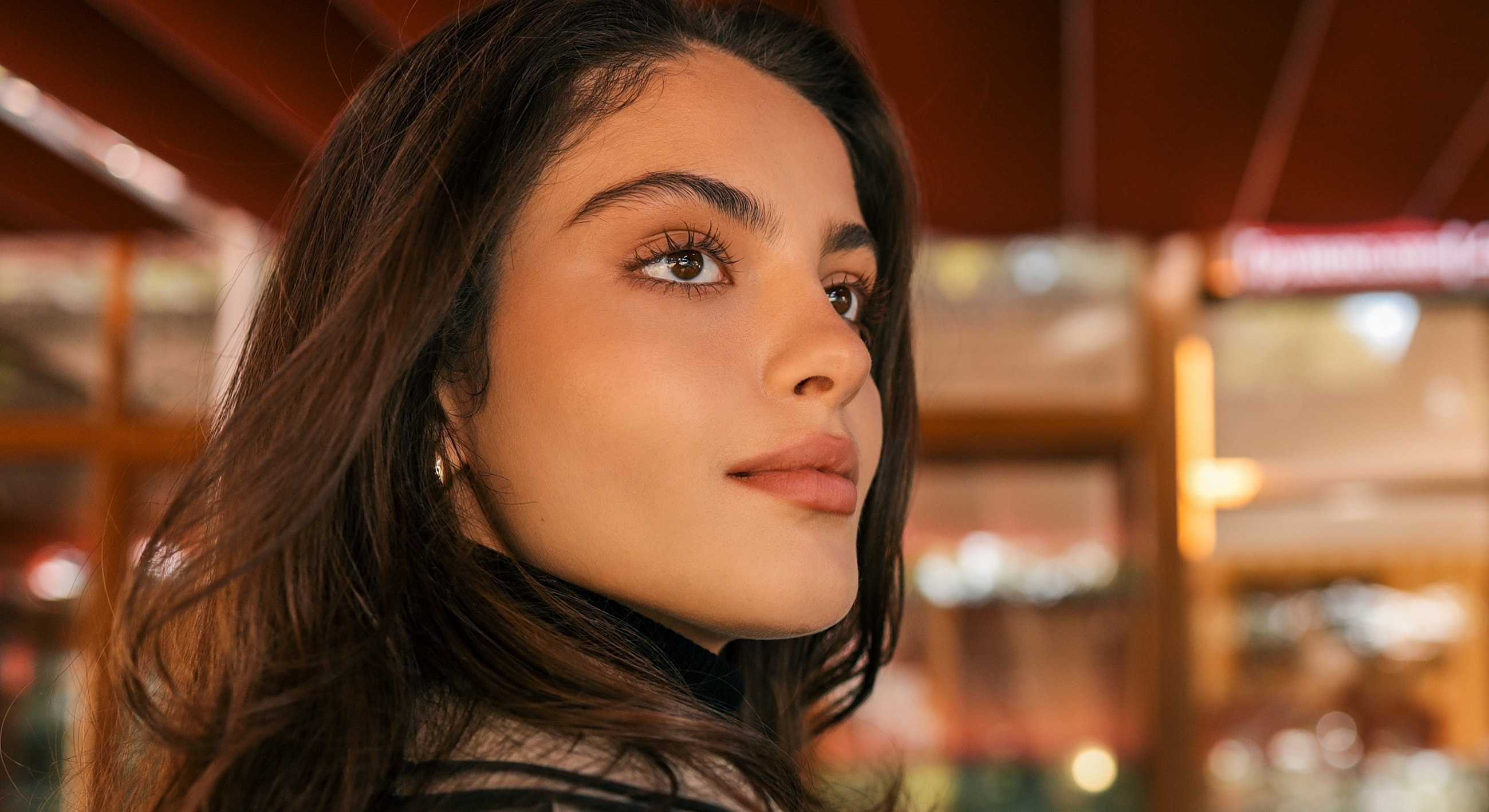 Close-up portrait of a young woman outdoors.