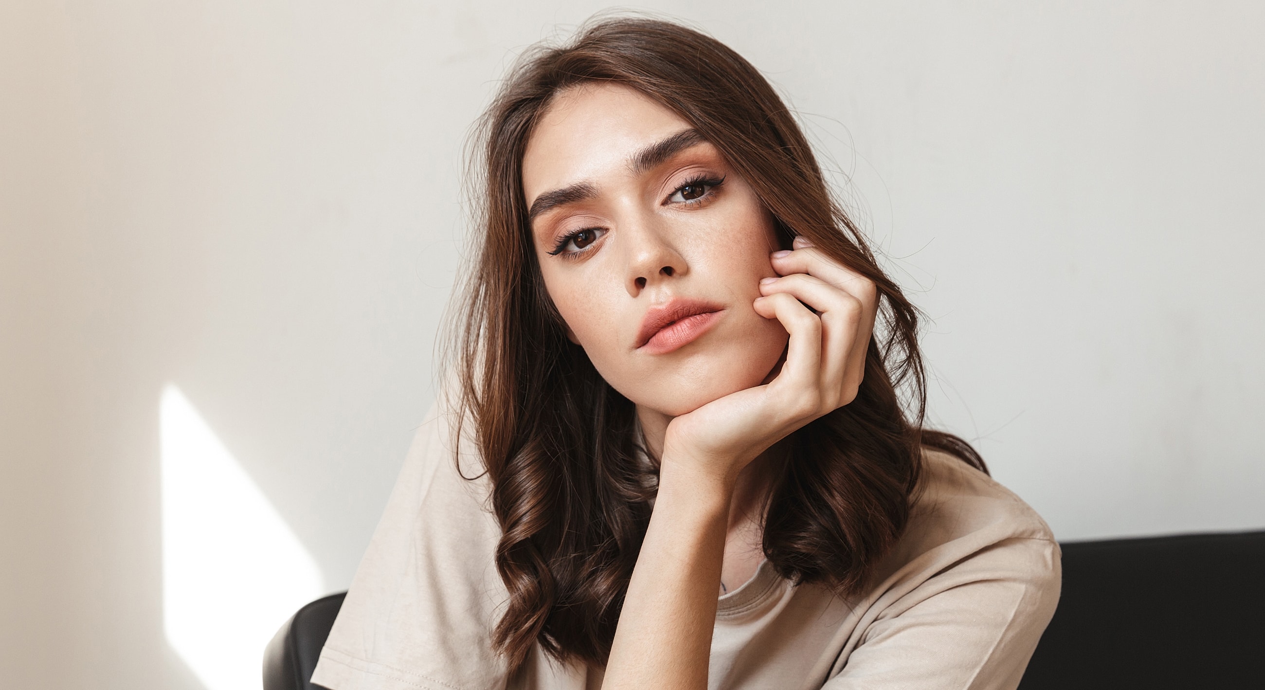 Young woman resting her chin on hand.