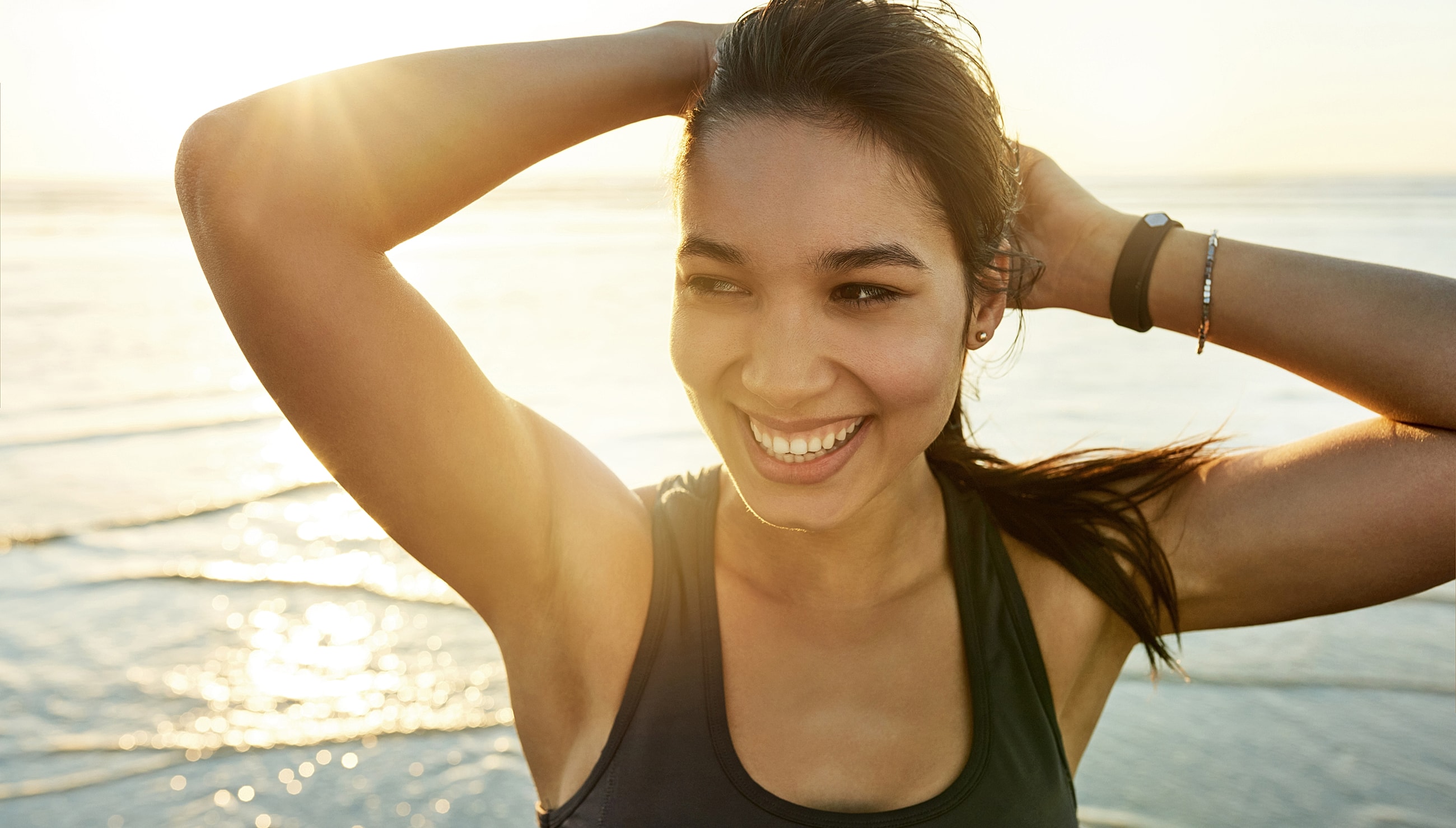 Smiling woman enjoying a sunny beach moment.