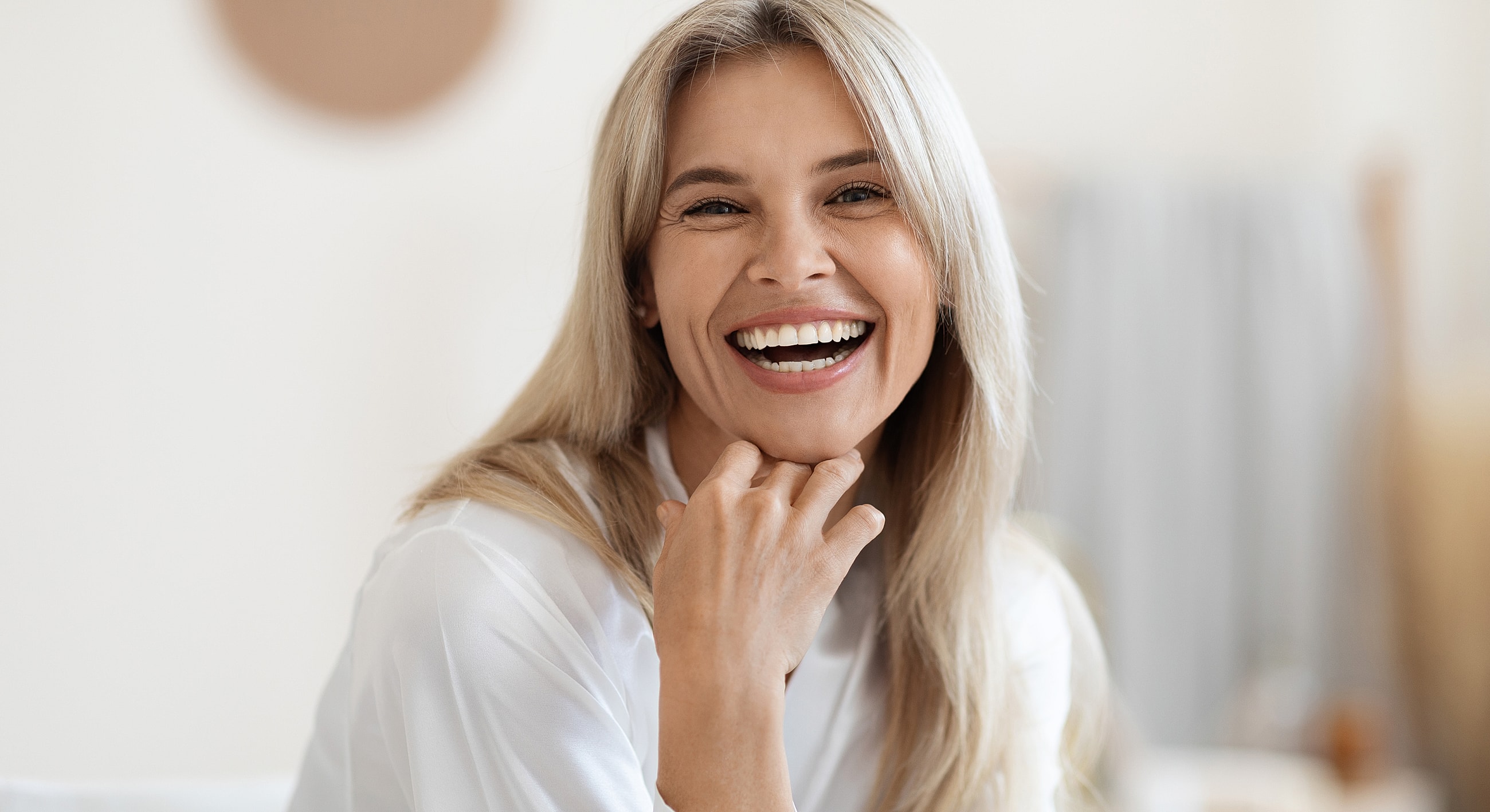 Smiling woman with long blonde hair indoors.